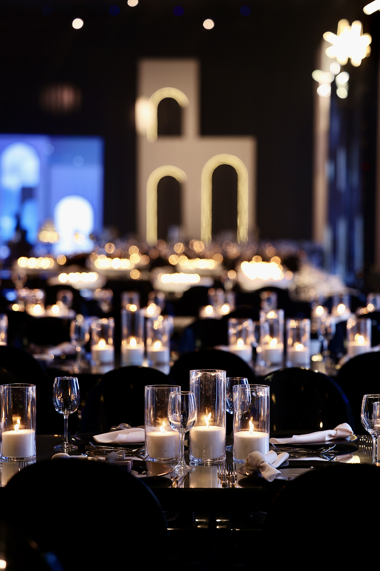 Dîner de gala, tables aux bougies et arches lumineuses